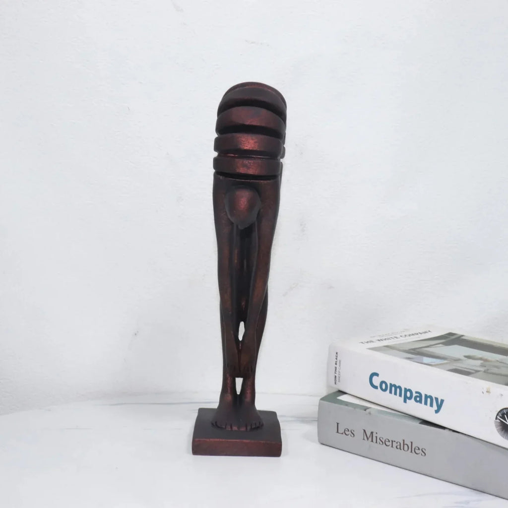 Decorative sculpture of a leg on a white surface with books in the background