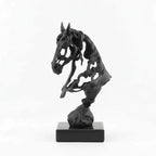 Black and gold horse sculptures on books with a gray background