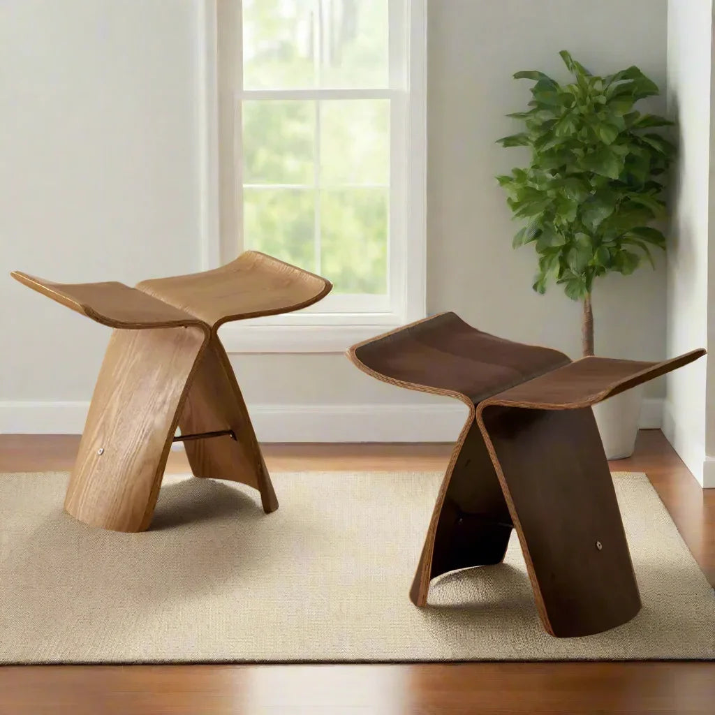 Two minimalist solid wood small stool ottomans with sleek sculpted design and natural wood grain finish for apartments