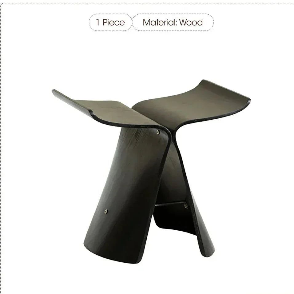 Black solid wood small stool ottoman with sleek modern design and curved seat for apartment living spaces
