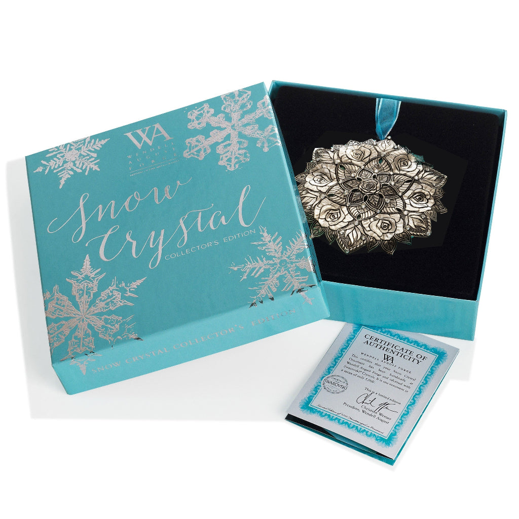 Silver snowflake ornament in a decorative box with 'Snow Crystal' branding.