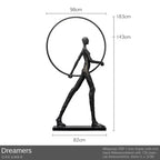 Black matte sculptural figure with iron frame and base next to a comforting velvet sofa cushion for living room decor