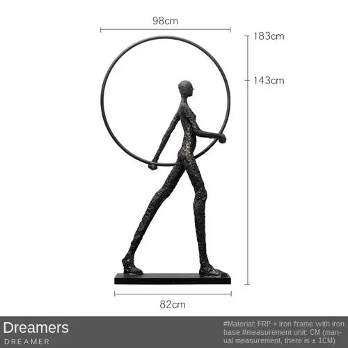 Black matte sculptural figure with iron frame and base next to a comforting velvet sofa cushion for living room decor
