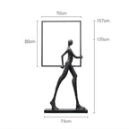 Black matte-finished abstract human figure sculpture holding a square frame for living room home decor