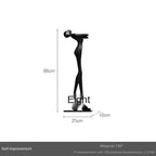 Black frp figurine with elongated limbs on rectangular base for modern home decor in living room or sofa cushion setting