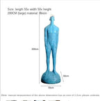 A tall blue resin human figure statue with textured skin on a matching base for living room home decor