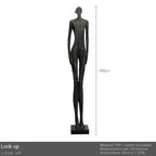 A tall slender black figurine with a textured surface on a matching base complements living room home decor