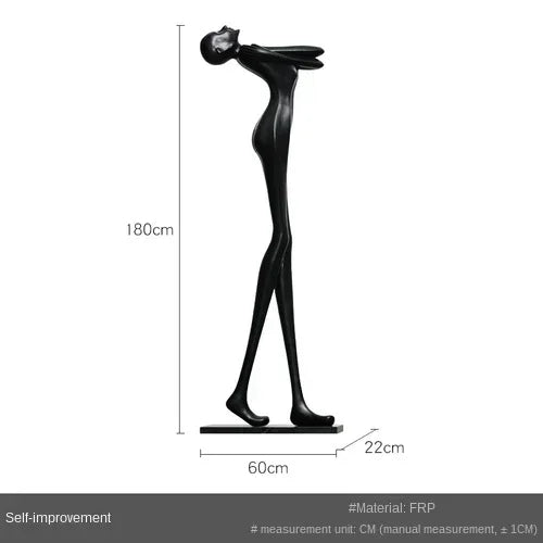 Black frp sculpture of stylized human figure with raised arms beside a comforting velvet large sofa cushion for living room decor