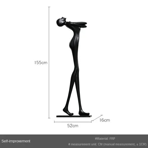 Black frp sculpture of stylized human figure on base displayed next to velvet sofa cushion for living room home decor