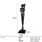 Black fiberglass sculpture of two stylized figures with one holding a book displayed as living room home decor