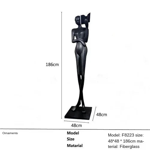 Black fiberglass sculpture of two stylized figures with one holding a book displayed as living room home decor