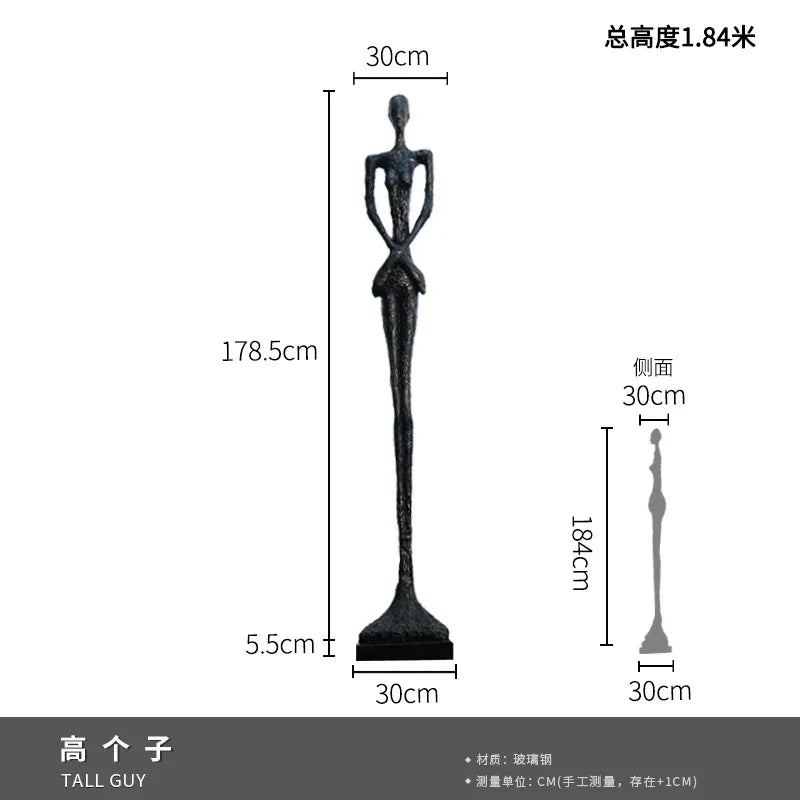 A tall slender black glass steel sculpture with elongated limbs paired with a comforting velvet sofa cushion for living room decor