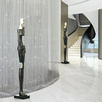 Black abstract sculpture with gold accents on black base displayed alongside large comforting velvet sofa cushion for living room decor