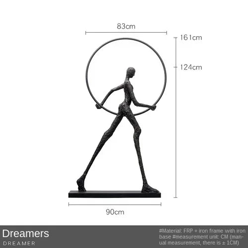 Black metal sculpture of a figure holding a circular hoop labeled dreamers enhances living room home decor
