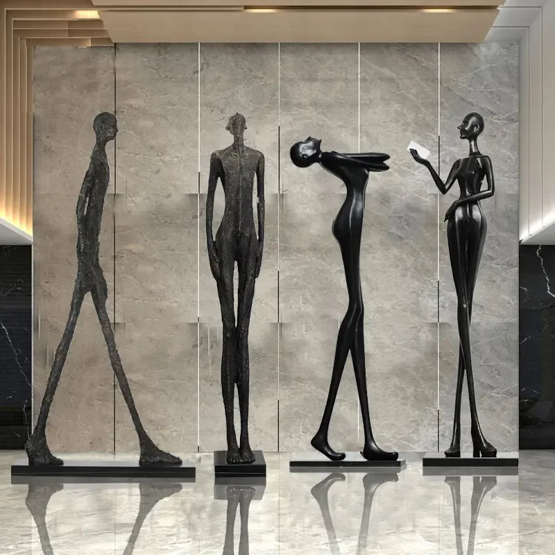 Four sleek black abstract figurines on bases complement living room home decor with velvet sofa cushion comfort design