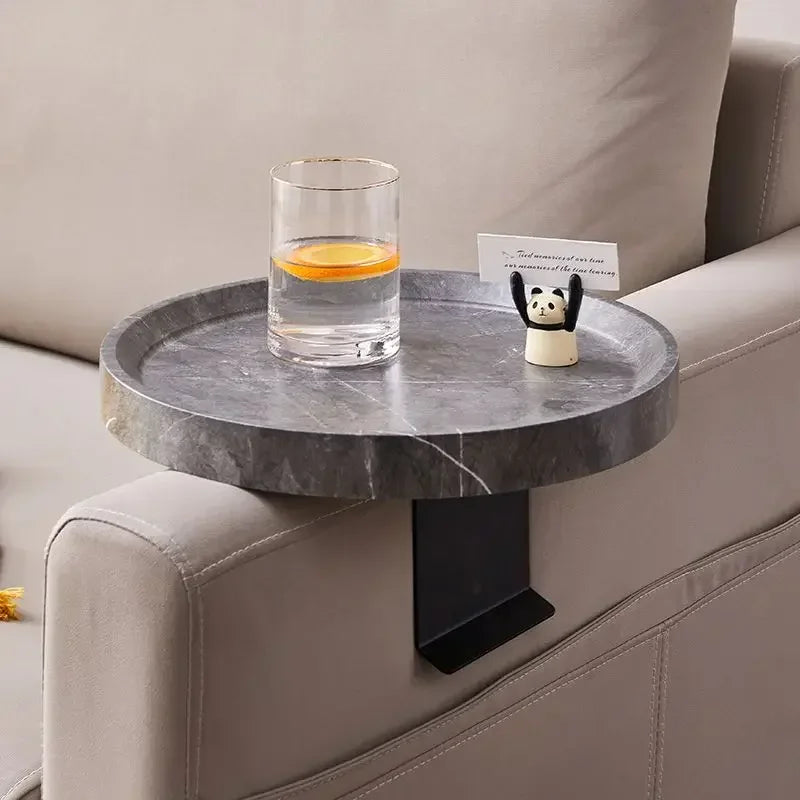 Gray marble-textured round sofa tray table with black metal arm attached to sofa for small spaces use