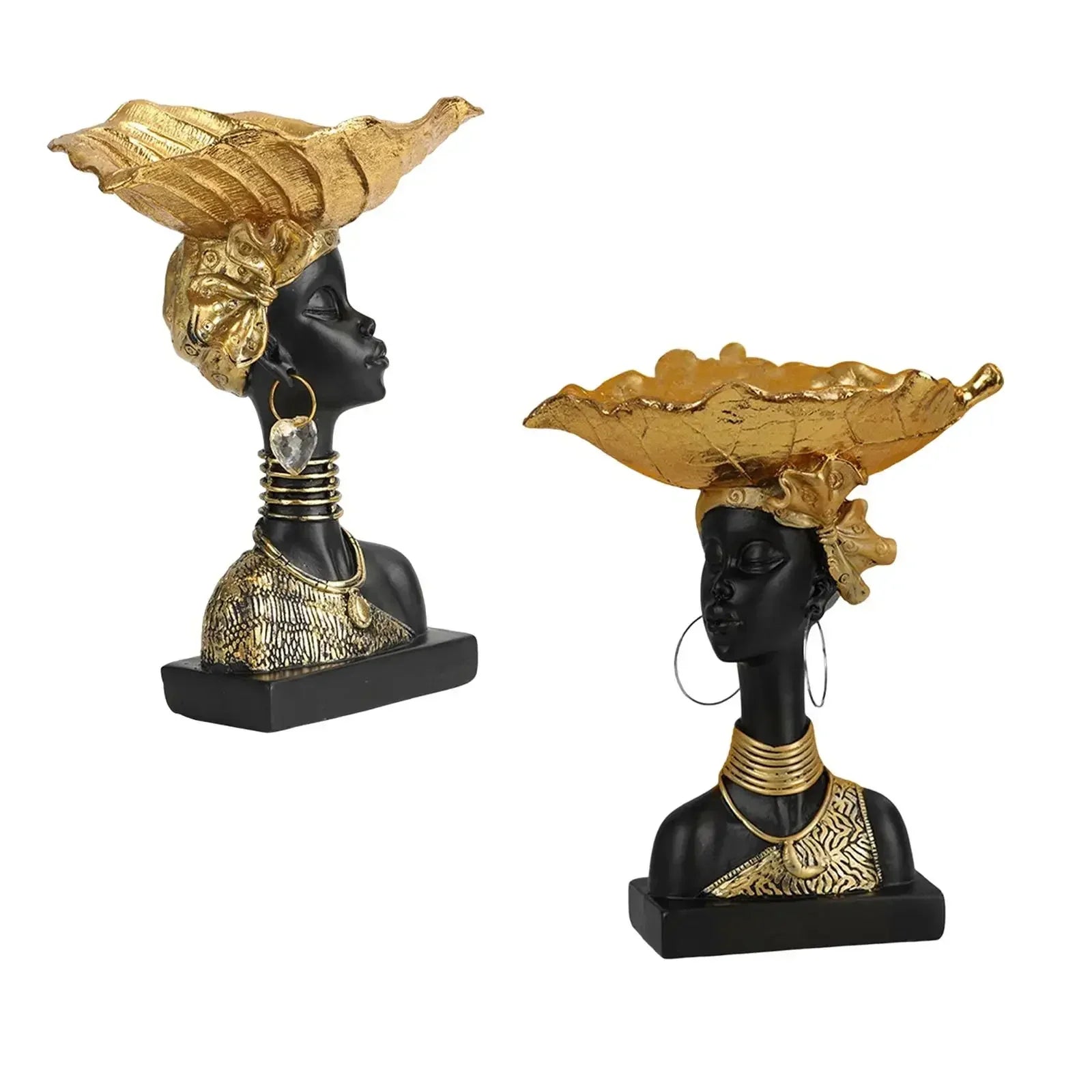 Black resin busts with gold leaf headdresses and jewelry displayed on a decorative wooden storage tray in modern style