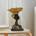 Black and gold resin bust on decorative wooden storage tray featuring a modern style with intricate golden accessories