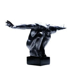 Black resin thinker statue of a crouching figure with arms outstretched for modern nordic decor and home decor