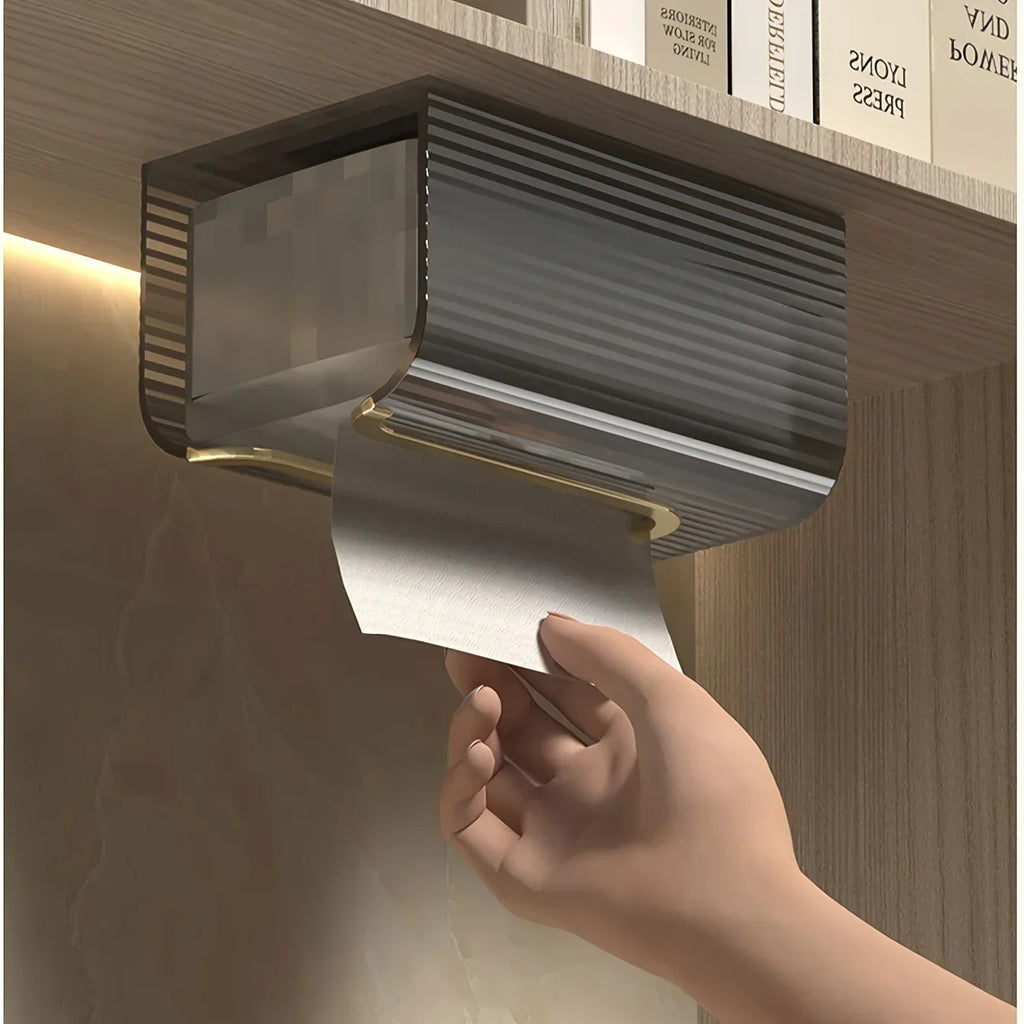 Wall-mounted paper towel holder dispensing a roll of paper towels with a hand reaching out to grab it.