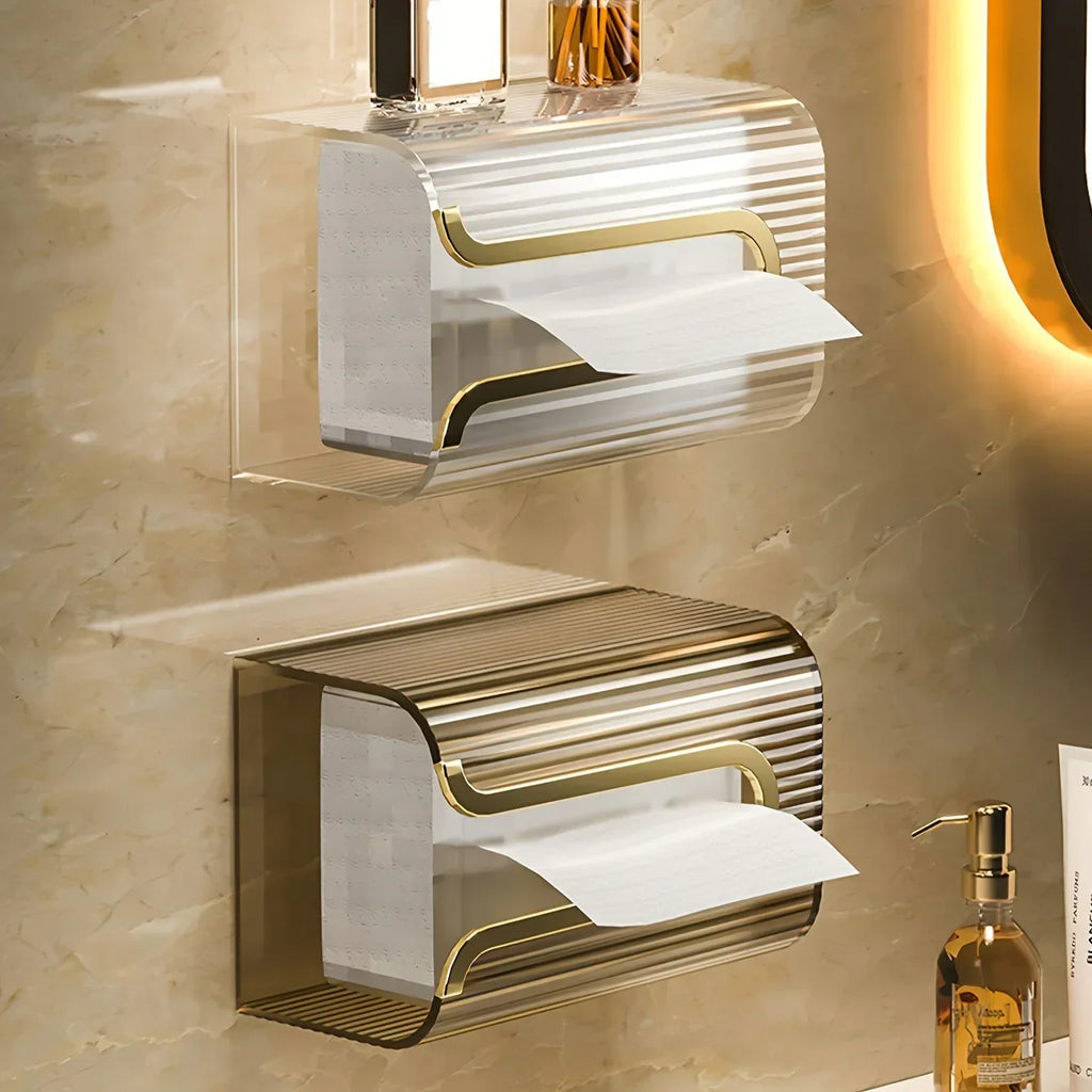 Gold and silver wall-mounted toilet paper holders on a beige tiled bathroom wall.