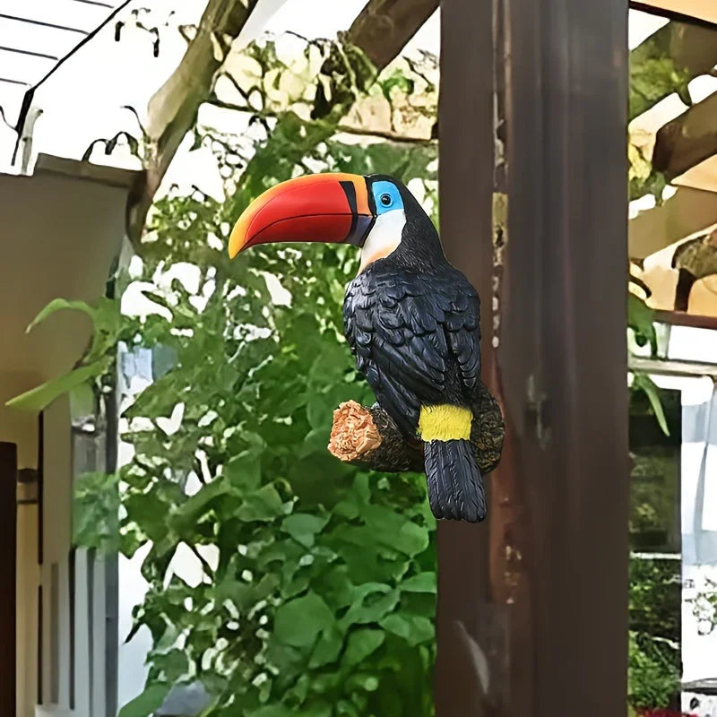 Decorative toucan bird figure on a branch with green foliage in the background