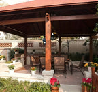 Outdoor patio area with wooden pergola, tables, chairs, and decorative plants.