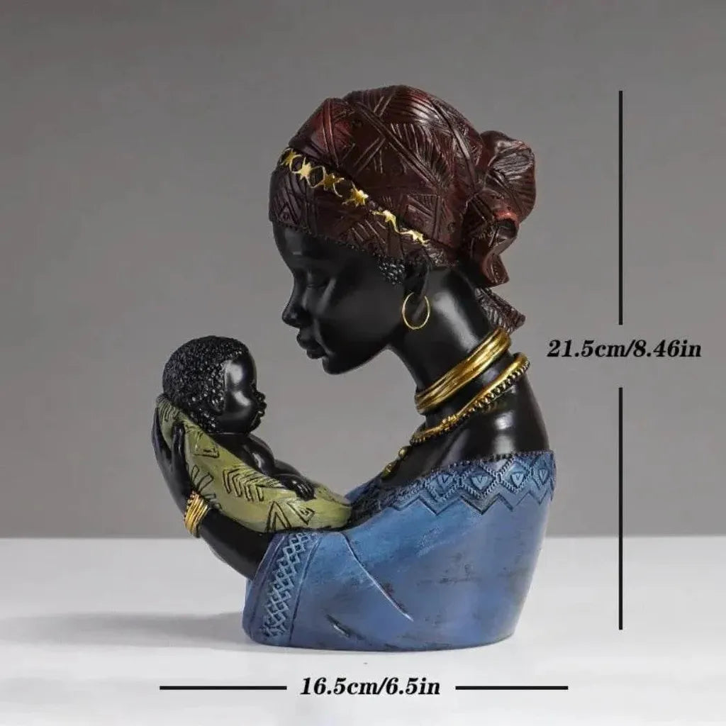 Glossy black resin traditional African mother figurine with gold-trimmed headwrap cradling a baby in profile