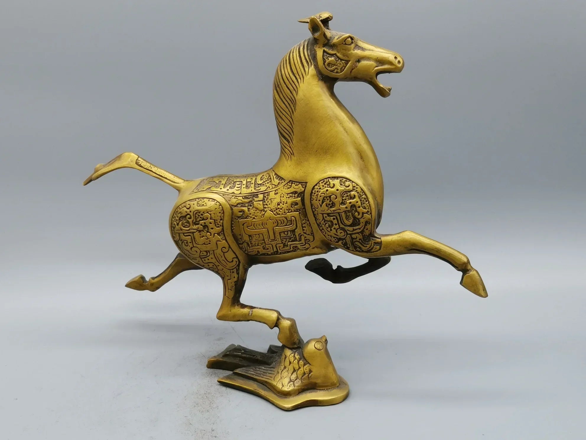 Vintage bronze running horse statue in dynamic pose with intricate engravings for luxury home and office decor