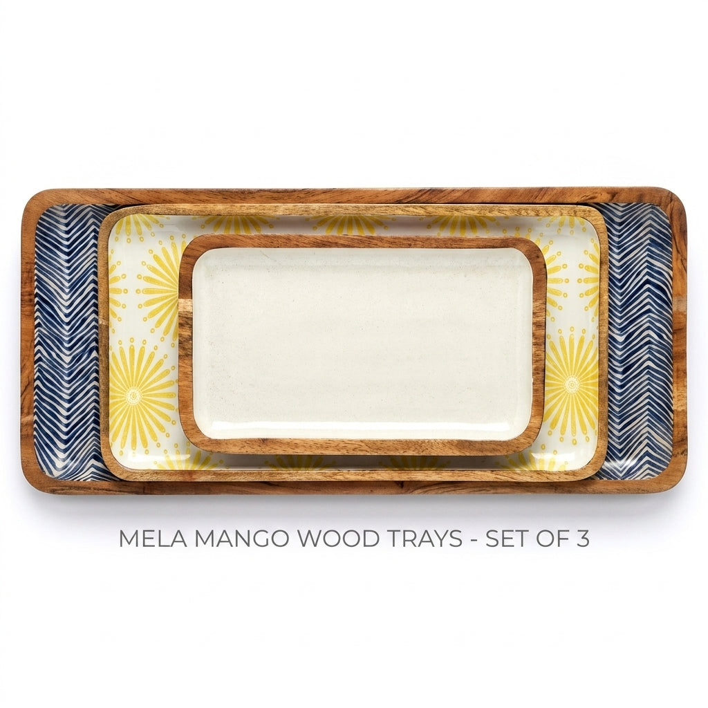Three nested rectangular wood serving trays with rounded corners, shown on a white background. The center tray is solid off-white, while the outer trays feature navy blue and yellow sunburst and chevron patterns.