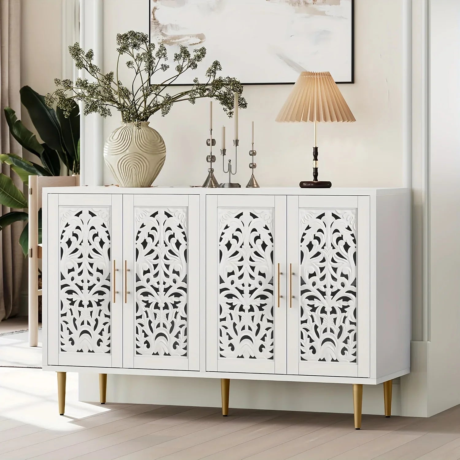 White cabinet with decorative patterns on doors in a room with plants and a lamp.