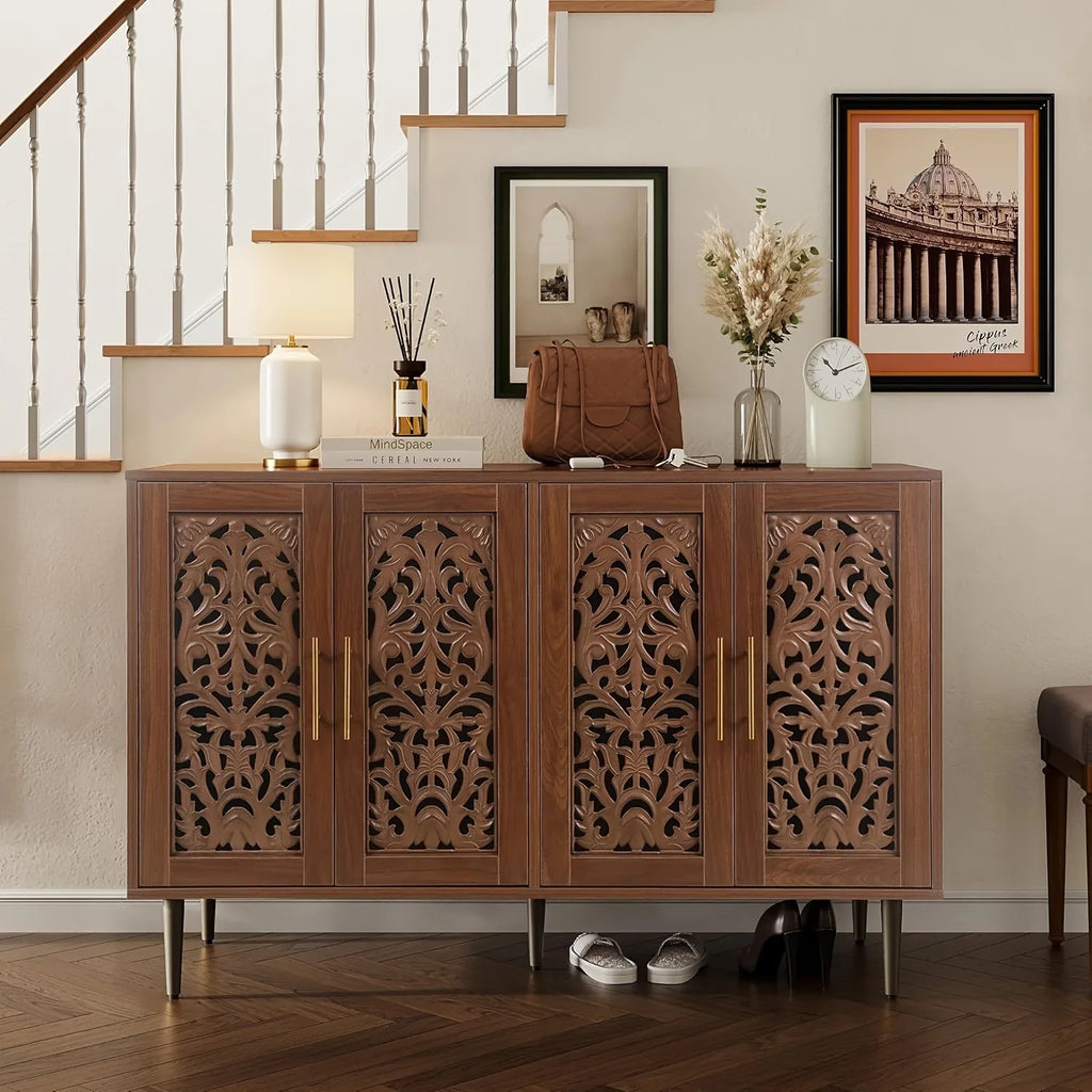 Wooden sideboard with decorative carvings in a room with a staircase and framed pictures.