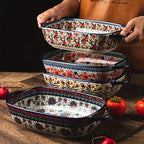 Two rectangular porcelain baking dishes with colorful bohemian floral patterns and side handles.