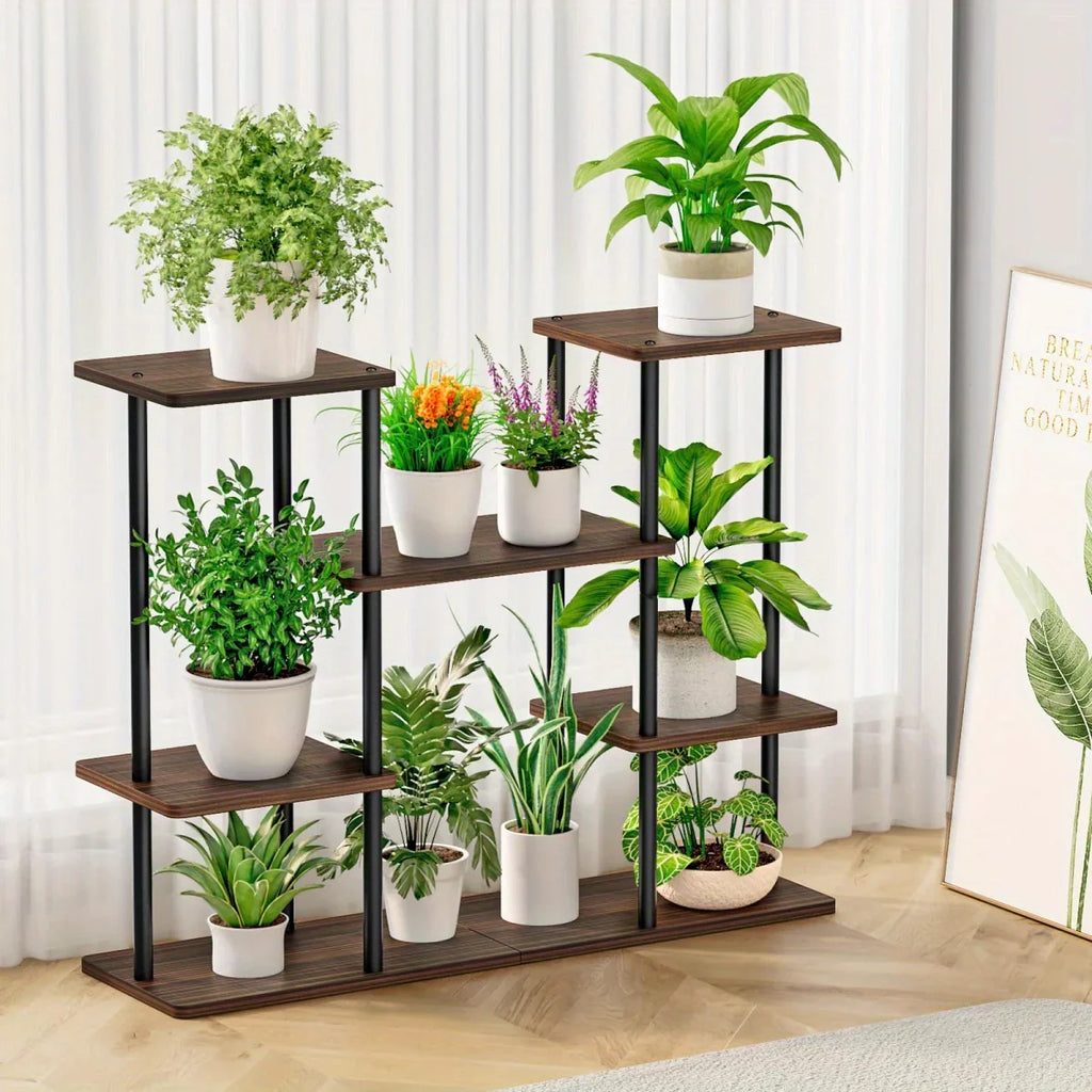 4-tier black metal and wood plant stand holding multiple green plants in a bright living room setting.