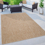 Mottled light brown and beige weatherproof outdoor rug on a modern patio with furniture.