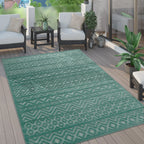 Turquoise boho indoor outdoor rug with a geometric high-low pattern displayed on a wooden patio deck.