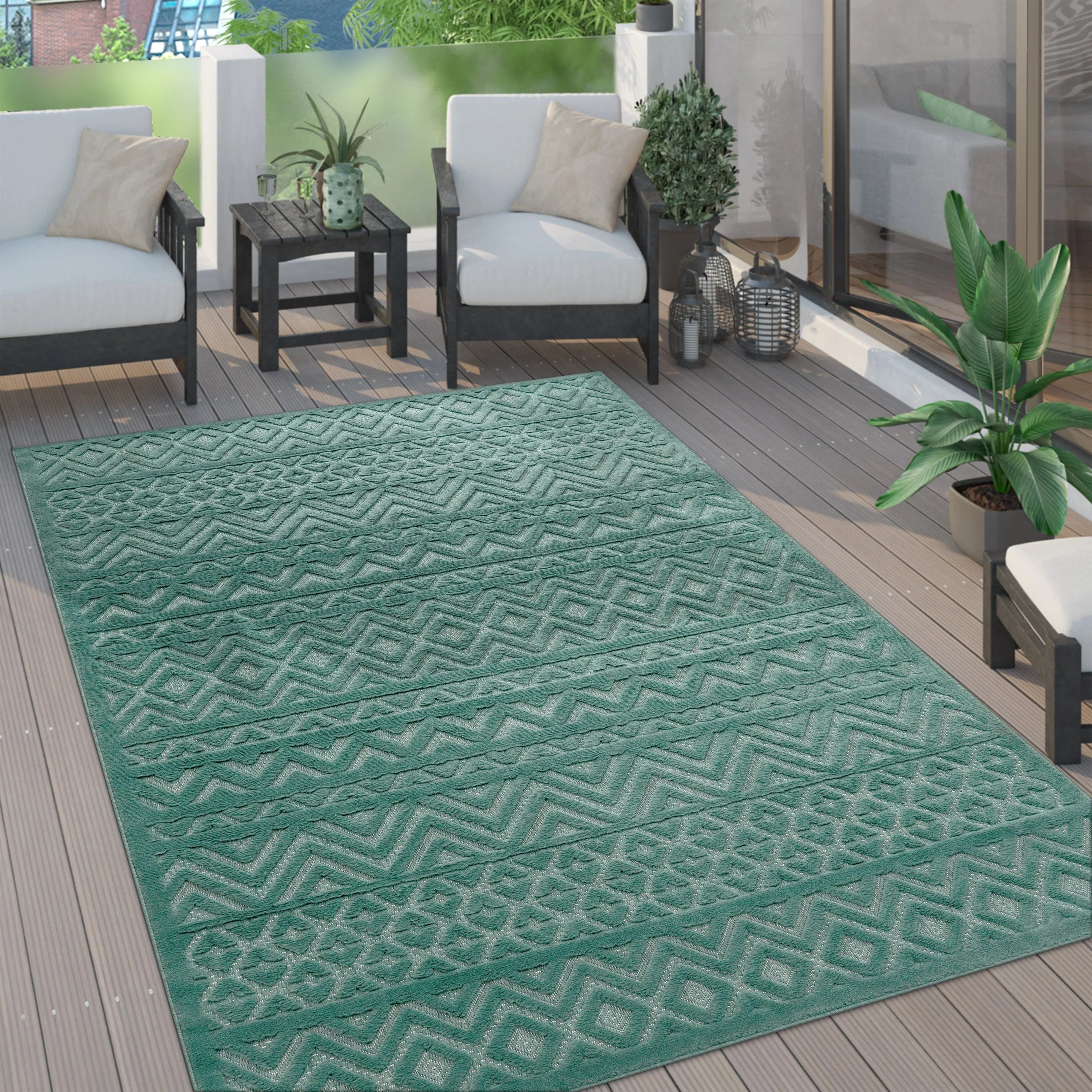 Turquoise boho indoor outdoor rug with a geometric high-low pattern displayed on a wooden patio deck.