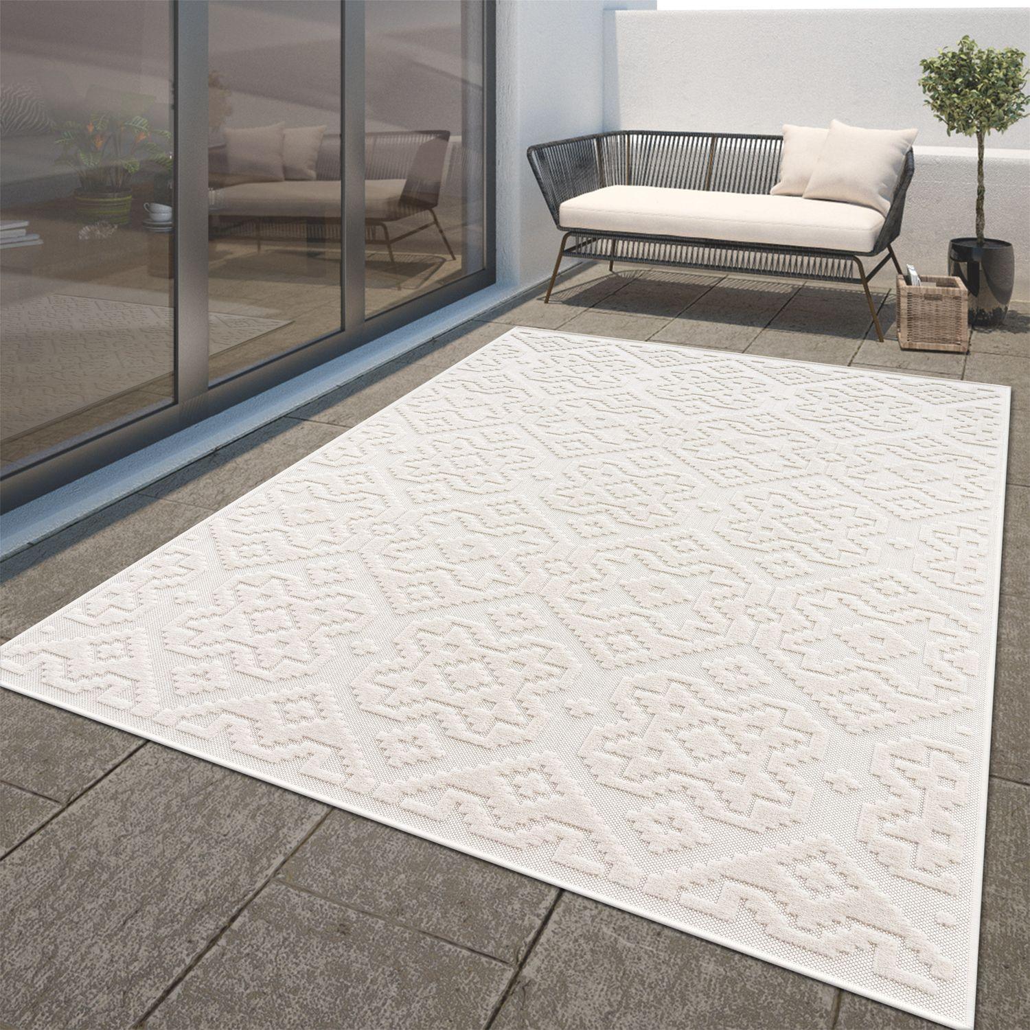 Cream indoor outdoor rug with a high-low diamond pattern on a modern patio.