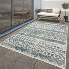 Turquoise and cream Marrakesh high-low trellis pattern rug on a stone patio with outdoor furniture.