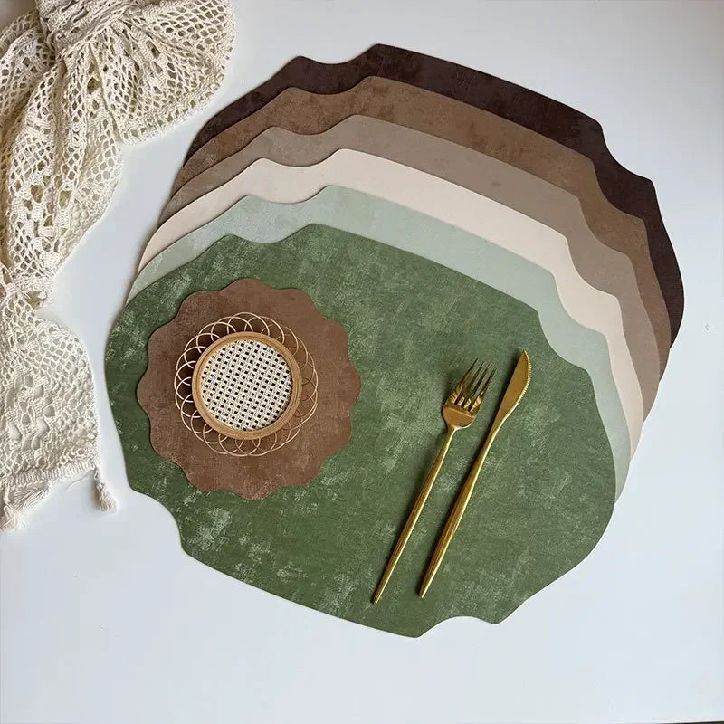 Set of green placemats with cutlery on a white surface