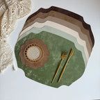 Set of green placemats with cutlery on a white surface