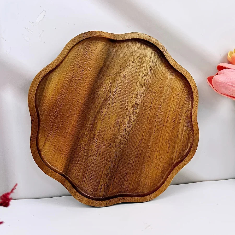 Plum blossom shaped acacia wood serving tray with natural polished wood grain.