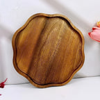 Plum blossom shaped acacia wood serving tray with natural polished wood grain.