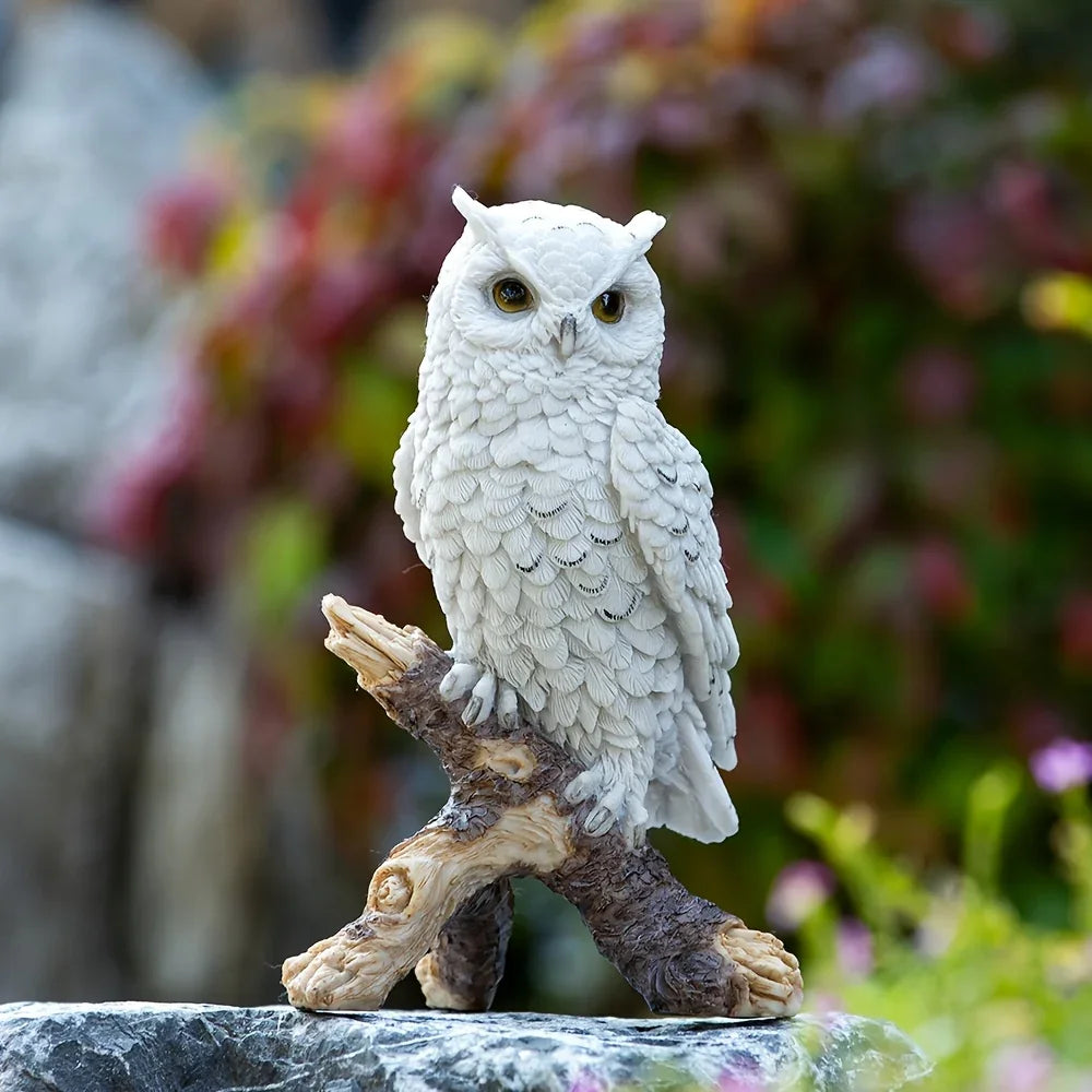 Highly detailed white owl statue perched on a branch in a garden setting.