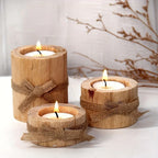Set of three rustic wooden tea light candle holders with burlap bows and warm wood finish.