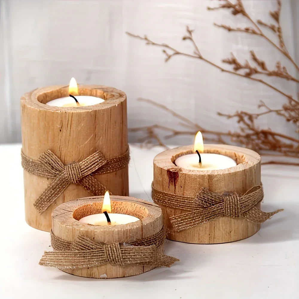 Set of three rustic wooden tea light candle holders with burlap bows and warm wood finish.