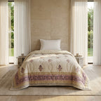 Sanganer print single bed quilt with purple floral motifs and a decorative border on a cream base.