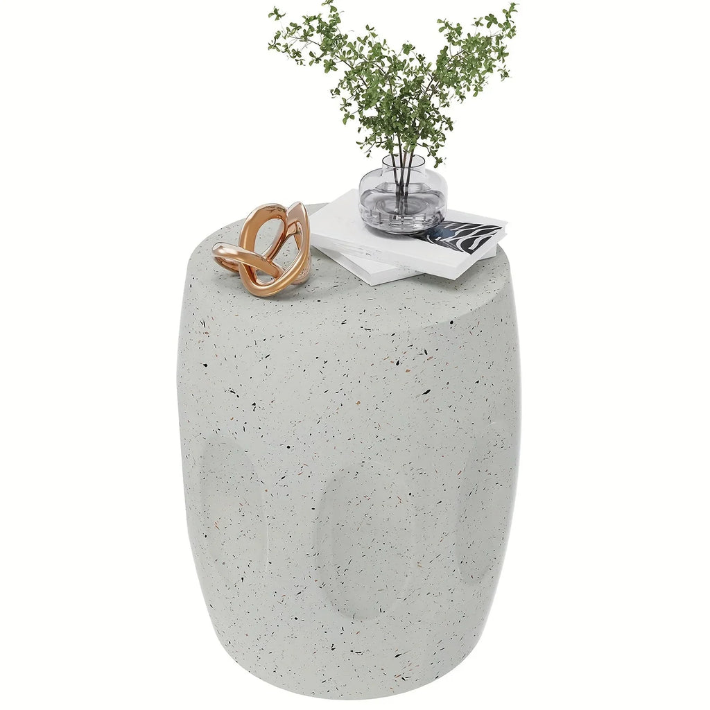 Light grey concrete drum side table with a speckled terrazzo finish and decorative oval indentations.
