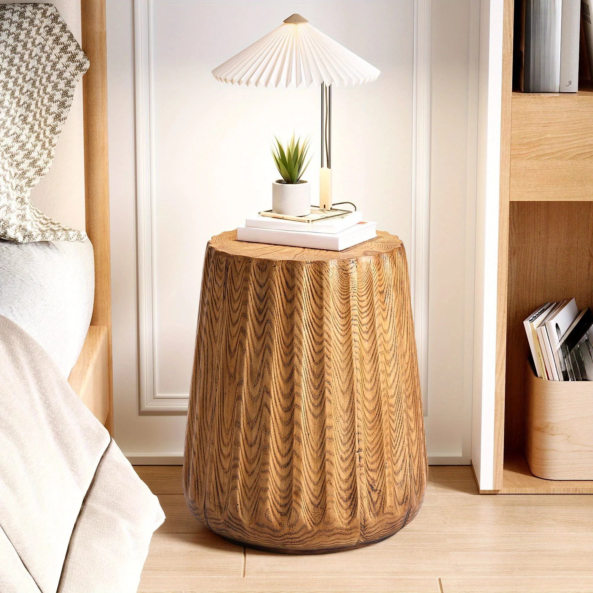 SUNBURY round faux wood side table with a textured grain pattern used as a bedside table with a lamp.
