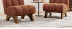 Two terracotta upholstered chairs with arched wooden legs on a light-colored textured rug.
